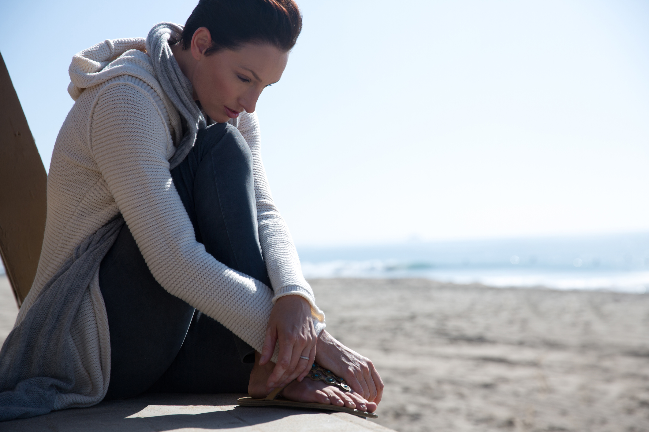 mujer sentada en la arena de la playa con un buen tránsito intestinal